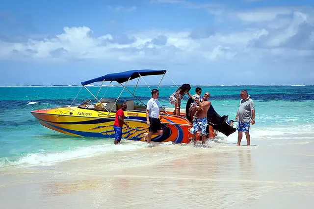 Guests boarding a speedboat in shallow turquoise water